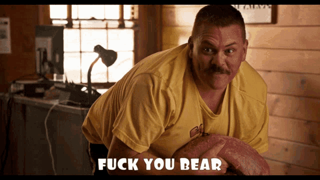 a man in a yellow shirt is holding a large piece of meat and the words fuck you bear are above him