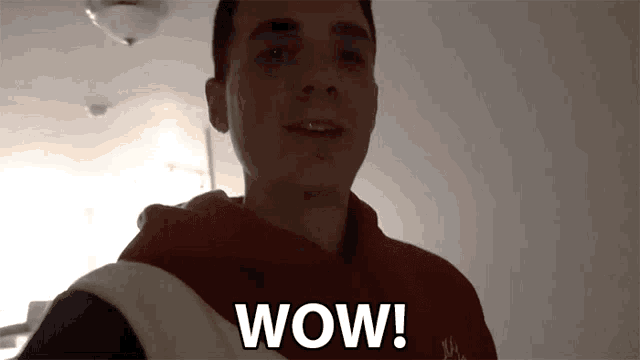 a man in a red hoodie says wow in white letters