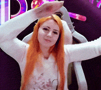 a woman with long red hair is standing in front of a sign that says d