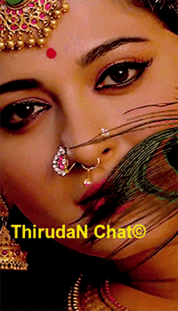 a close up of a woman 's face with a peacock feather in her mouth and the words thiruda chat written below her