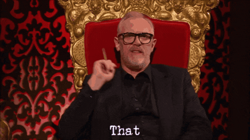 a man in a suit and glasses is sitting in a chair with the word rubbish written on the bottom