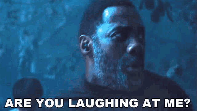 a man with a beard is laughing at the camera .