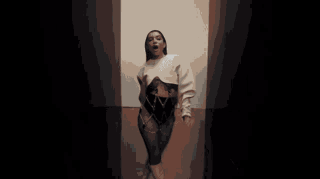 a woman with a tattoo on her chest is wearing a white sweater