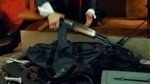 a person is holding a rifle in their hand while laying on the floor