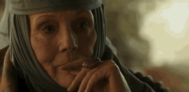 a woman with a ring on her finger is wearing a turban