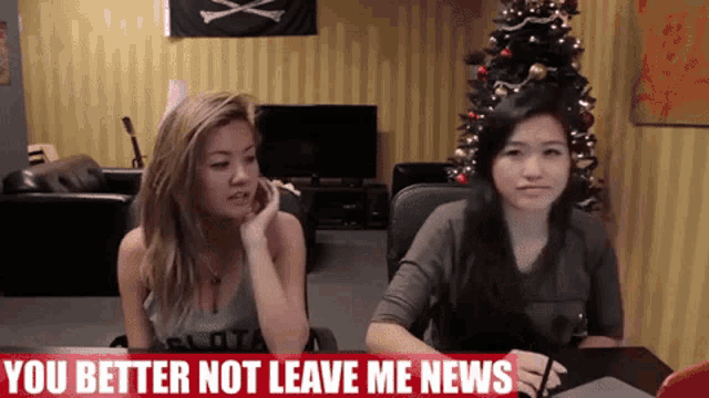 two women sitting at a table with a sign that says you better not leave me news on it