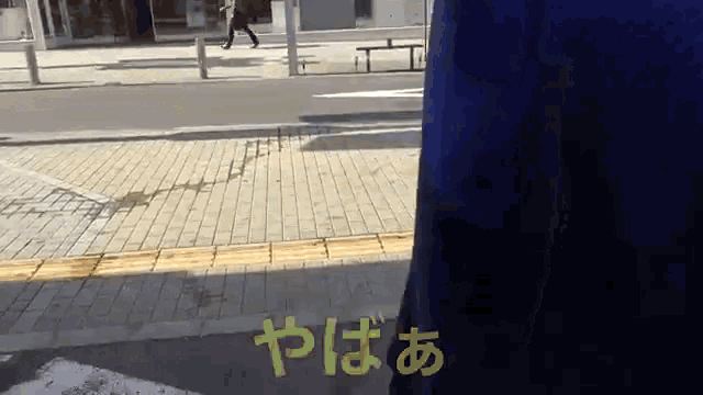 a person walking down a sidewalk with a yellow sign that says yaba
