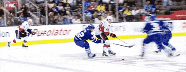 a hockey game is being played in front of a sign that says purolator