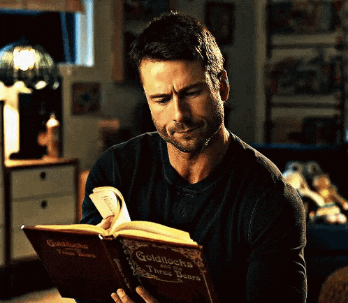 a man is reading a book called goldilocks and three bears