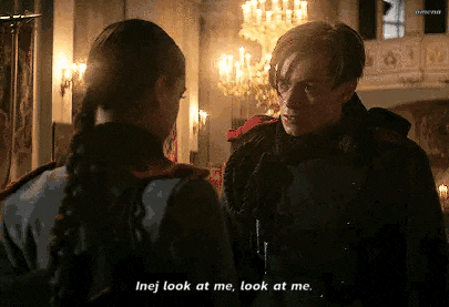 a man and a woman are standing next to each other in a room and the man is talking to the woman .