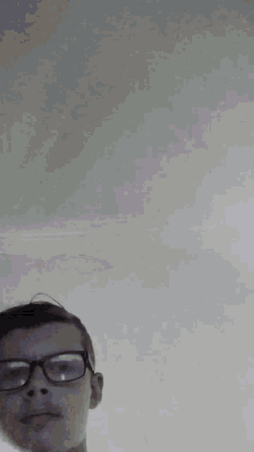 a blurry image of a man wearing glasses