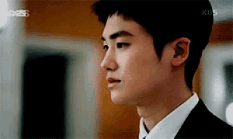 a close up of a man in a suit and tie looking at something .