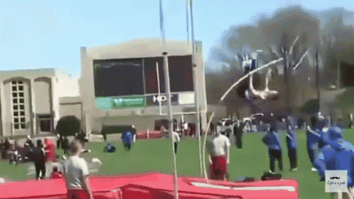 a man is jumping a pole in front of a building that says hd