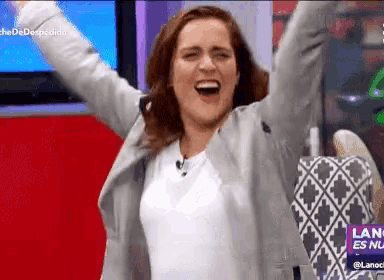 a woman is raising her arms in the air in front of a sign that says lanoche