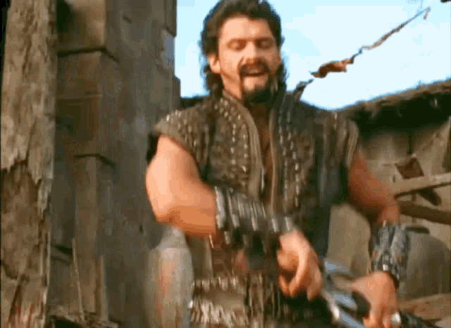 a man with a beard is holding a sword in his hands