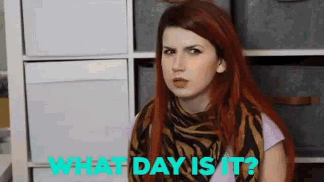 a woman with red hair is wearing a zebra print scarf and asking what day is it .
