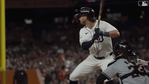 a baseball player is swinging a bat at a ball in a game .