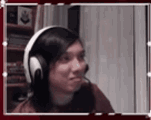 a woman wearing headphones and a microphone is sitting in front of a computer .