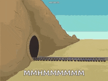 a train is going through a tunnel in the desert next to a mountain .