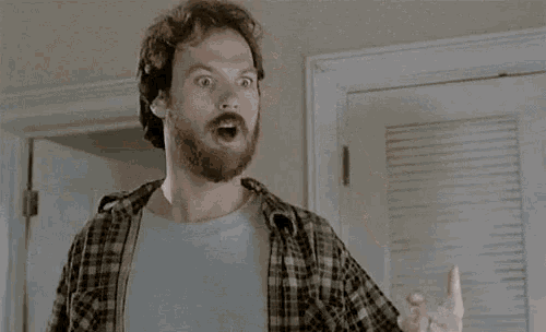 a man with a beard is pointing his finger at the camera and saying `` i 'm losing it ''