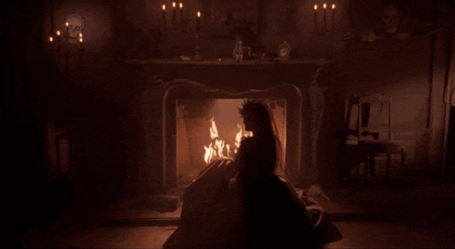 a woman with a cross on her ear is holding a torch and says i was just warming my hands in the fire