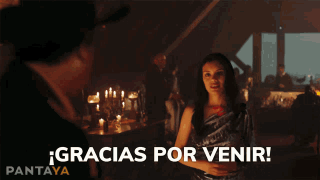 a woman stands in front of a man with the words gracias por venir written on the bottom