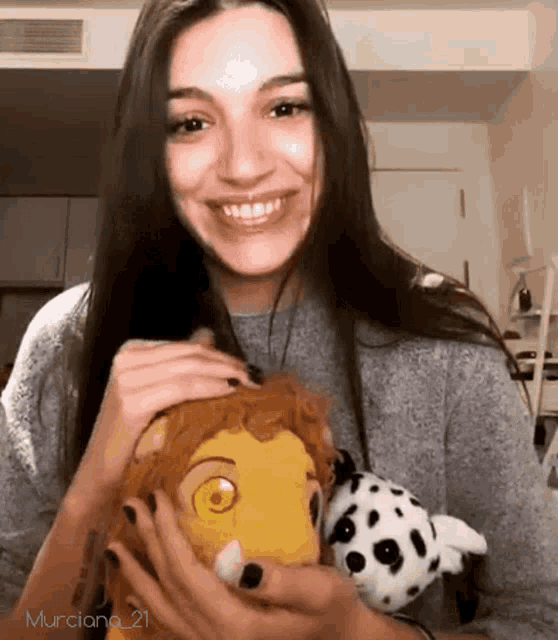 a woman is smiling while holding a stuffed animal and a dalmatian dog