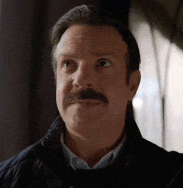 a man with a mustache wearing a black jacket