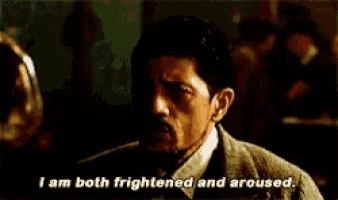 a man in a suit and tie is saying " i am both frightened and aroused "