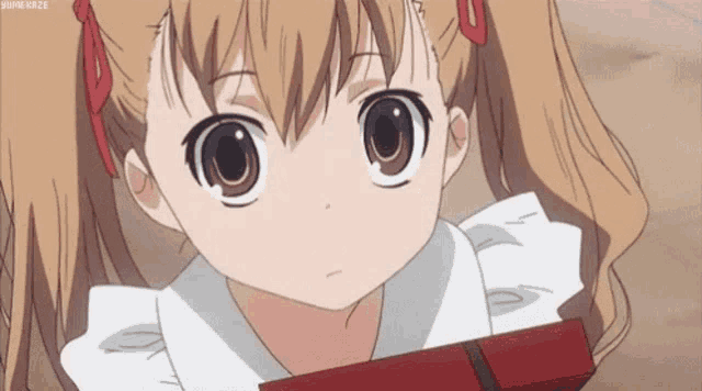 a little girl with pigtails is holding a red box in her hands .