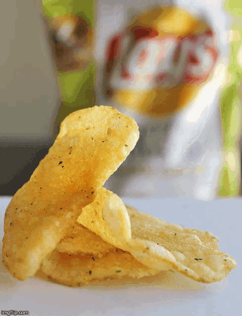 a bag of lay 's chips is behind a stack of chips