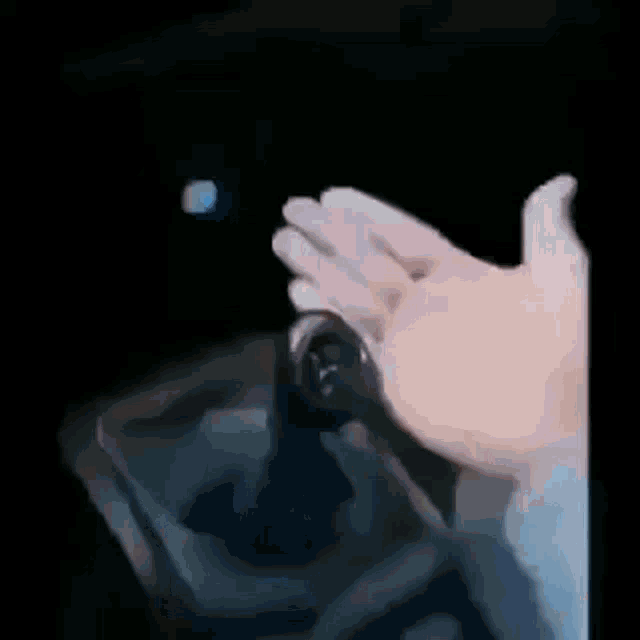 a close up of a person 's hand pressing a button in a car .