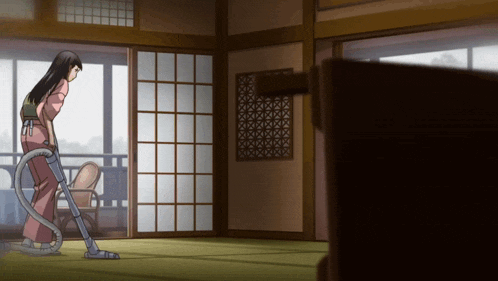a woman is using a vacuum cleaner in a room with sliding glass doors