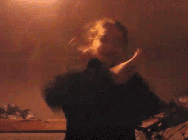 a blurry picture of a person with their arms outstretched in a room