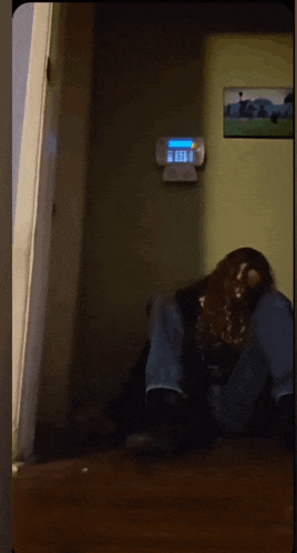 a person laying on the floor in front of a wall with a clock on it