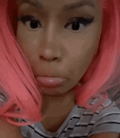 a close up of a woman wearing a pink wig and smiling .
