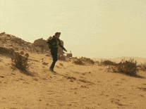 a man is walking through the desert with a backpack