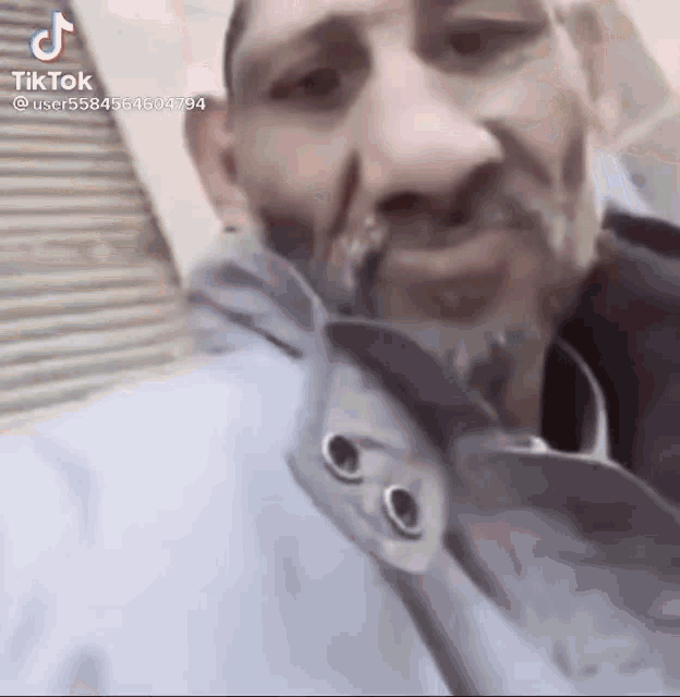 a close up of a man 's face with a tik tok watermark on the bottom