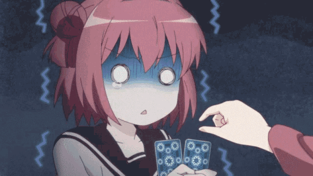 a girl with pink hair holds a pair of cards