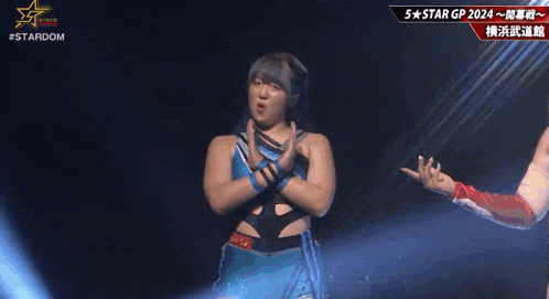 a woman is standing on a stage with her arms crossed and making a face .