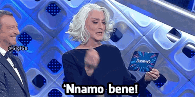 a woman holding a card that says nnamo bene