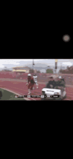 a blurred image of a football player running on a field with a golf cart in the background .