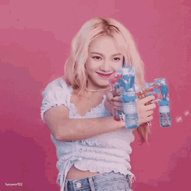 a girl with blonde hair is holding a soap dispenser in front of a pink background with hyoyeon922 written on the bottom
