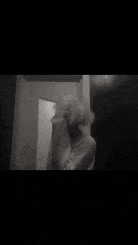 a black and white photo of a person standing in front of a mirror with smoke coming out of their head .