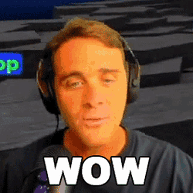 a man wearing headphones and a black shirt with the word wow on his face