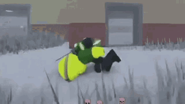 a green and yellow robot is laying on the ground in the snow .