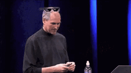 steve jobs is wearing a pair of sunglasses while giving a speech on a stage .