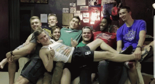 a group of young men are posing for a picture and one of them is wearing a shirt that says tank