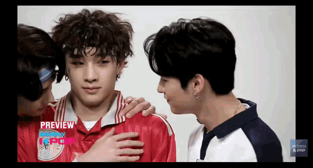 a group of young men are standing next to each other and one of them is wearing a red jersey