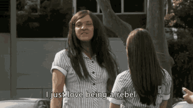 two women are standing next to each other and one of them is saying i just love being a rebel